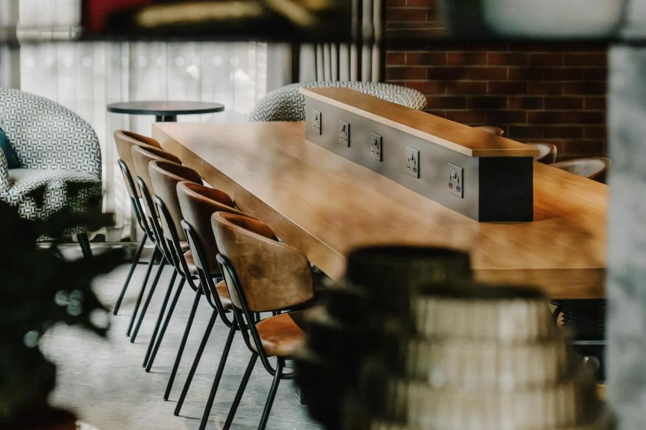 a row of chairs around a wooden table in a restaurant at The Halyard Liverpool, Vignette Collection by IHG in Liverpool