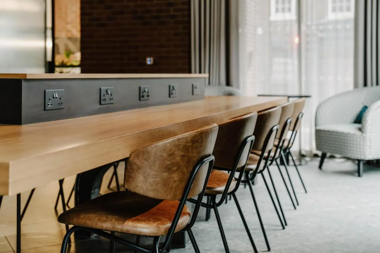 a row of chairs lined up at a bar at The Halyard Liverpool, Vignette Collection by IHG in Liverpool